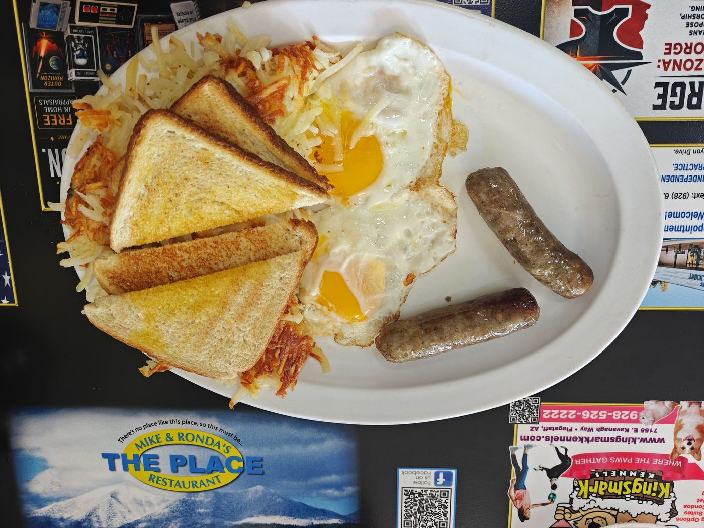 Two eggs with sausage links, hash browns and toast